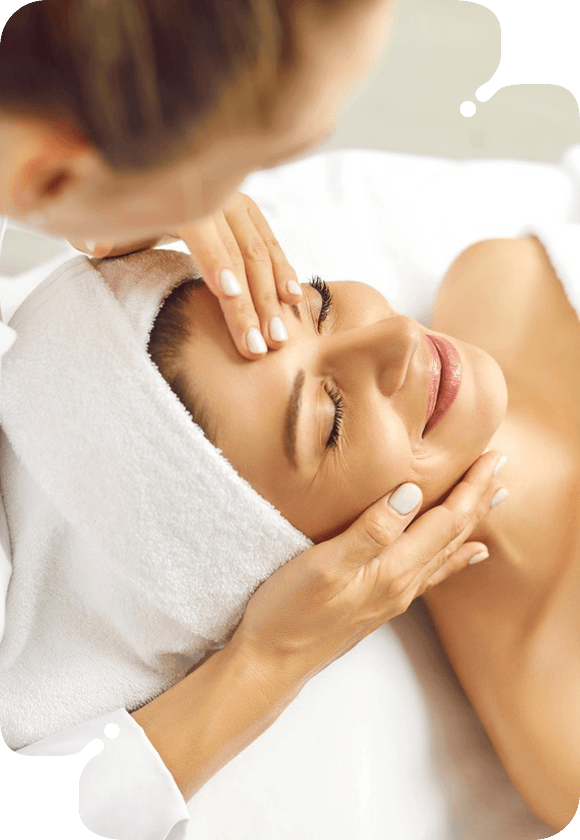 A woman enjoying a relaxing facial massage in a serene spa.