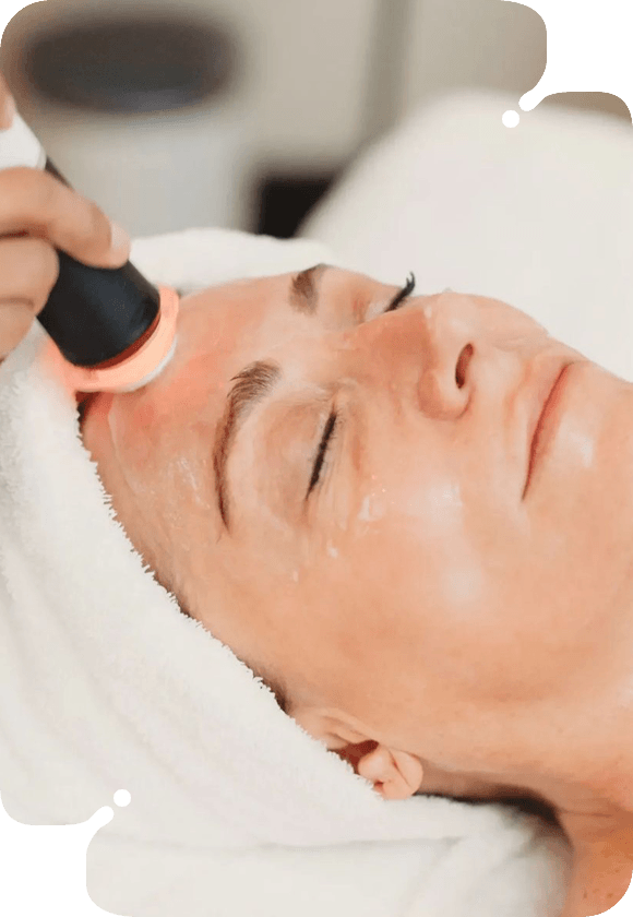 A woman receiving a radio frequency facial treatment for skin firming.
