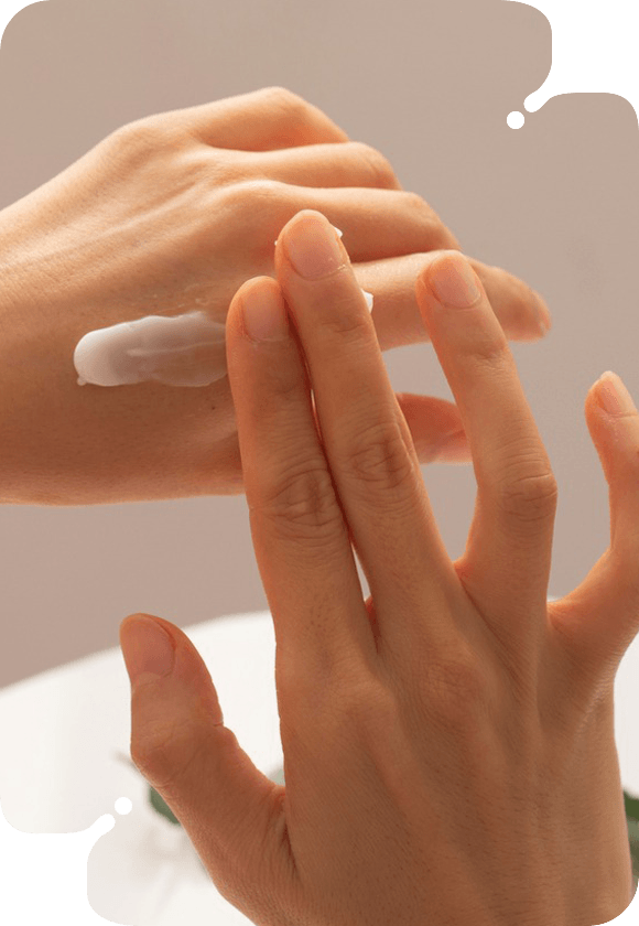 Individual using cream in a hand treatment routine.