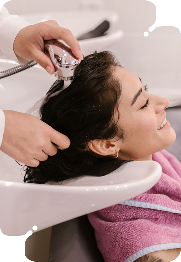 A woman's butt with a water droplet, showcasing the results of a Purifying Scalp Treatment for hydration.