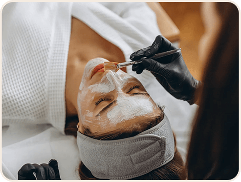 A woman receiving a facial at a spa, promoting a new skincare service.