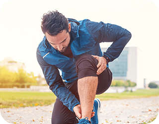 A man stretches his leg while running, emphasizing foot and ankle flexibility.