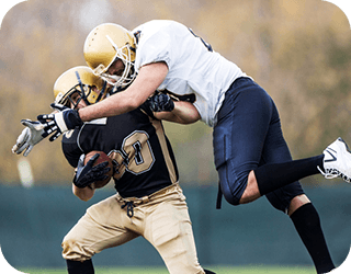 Two football players leap for the ball.