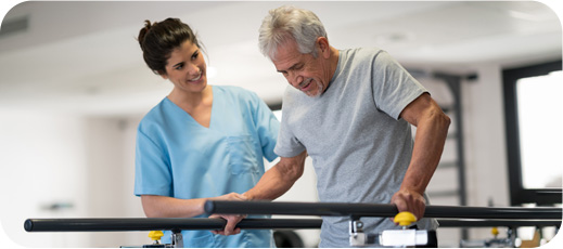 Therapist assisting older patient during rehabilitation