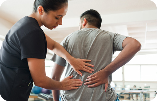 Physical therapist assisting a patient with back pain